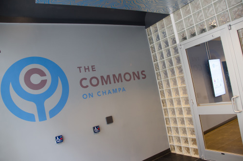 Entrepreneurs and Community Partners Mingle And Collaborate To Celebrate The Grand Opening Of The Commons Last week’s opening of the Commons at Champa brought together entrepreneurs and members of Denver’s business community to celebrate the historic project made possible by dozens of public and private partners. The first of it’s kind in the nation, the Commons on Champa seeks to be a entrepreneurial resource center in the middle of Denver’s bustling downtown. Opening day festivities included panel discussions, tours of the new space, town-hall style conversations with leading business providers and a startup celebration featuring food and drink from a variety of Denver restaurateurs.[[MORE]]While the various organizations and partners who came together to make the building a reality were breathing a final sigh of relief the space was finished, participants on the day echoed a common refrain, embracing the unknown and looking forward to serendipities that may emerge from bringing the entrepreneurial community together under one roof.Jay Zeschin, a co-founder of Ello and an organizer of Denver Startup Week, said he could already see the basecamp feeling of Denver Startup Week starting to take hold in the space at Champa. There’s an opportunity for serendipity and chance encounters to lead to bigger things, something people who have participated in Denver Startup Week have already discovered, but the intention is to keep this flame alive permanently at Champa. A movement is developing in Denver around entrepreneurship, and Commons on Champa is in the center of the action.  Among the resources already calling the Commons on Champa home are the City of Denver’s Office of Economic Development and the Colorado Technology Association, both of which have offices on the second floor where they will be joined in the coming months by other non-profit businesses with a focus on entrepreneurship. The Office of Economic Development will highlight available programs offered by the city, which includes a loan program capable of financing up to $300,000 towards projects expenses in the Denver city limits. The office targets 12 industries in the state for growth, but ultimately the OED is working towards a goal of making Denver the entrepreneurial capital of the world. With their satellite office at the Commons, they are making progress towards reaching that goal and connecting entrepreneurs with opportunities they may not even know exist.The Colorado Technology Association represents Colorado’s advanced industries, using technology as a unifying thread. The association provides networking opportunities for it’s members, which include large companies, startups and even IT departments within companies that are not tech focused.The CTA, led by Erik Misitek, and a driving force behind the Commons, has 3 platforms – education of workforce, economic development, and public policy advocacy. With an ear to the ground, officials at the CTA hope to provide a voice for entrepreneurs in shaping public policy, and connections through their various networking opportunities. Outside the CTA’s offices, Jason, a tech support team member from Itonish, a partner on the Commons project, which provides IT solutions to companies, was sitting among the empty desks working on his laptop. “I have been working on the IT in this space for several months, but now it is coursing with the energy and excitement of the community. It’s exciting.”  Meanwhile, downstairs entrepreneurs and resource partners gathered in the event spaces and halls to discuss the entrepreneurial scene in Denver. Victoria Smith operates Legends of the Hidden Potential, a marijuana trim company, and has been looking for a space to meet with potential investors. She stopped into the Commons to see what kinds of businesses resources might be available at Champa to support her growing business. It’s this kind of can do attitude, that was being discussed on panels in the next room. In an uncommon twist, millenials, of which Smith is one, were being lauded by older members of a panel for their adventurous spirit, “young people are bucking up and saying, ‘I’m going to go out and do this for myself.” And for these eager pioneers, Rob Smith, of Rocky Mountain Micro Finance Institute, led a panel on resources available to small businesses and the Commons will be featuring panels like this on a regular basis.In the entrepreneurial café, which features tables and free wifi from Xfinity, some of Denver’s most successful and upcoming restaurateurs were handing out samples of their delicious products, in addition to checking out the new space. “My office is my kitchen, so this will be a great space to use when I need to have important meetings,” voiced Patrick, owner of Elevation Ketchup, a gourmet food company that can be found at the Four Seasons restaurants and Root Down. At the next table, Jake Broadsky, owner of the popular Denver coffee company Novo, was being modest about his success, but was open to opportunities to mentor aspiring food businesses in Denver.On the way out, a bright blue mural adorns the doorway designed by the artist known as Alex the Amazing Artist. A Denver local, and student at CU Denver studying illustration, Alex was passing by the building and offered up his services. It’s this kind of entrepreneurship, collaboration and community the planners behind the space envisioned and how the space has come to be. A massive collaborative effort fueled by entrepreneurship and community, the space has been made for this unprecedented movement to take shape, and now it is up to us to dig in.By Emily Przekwas